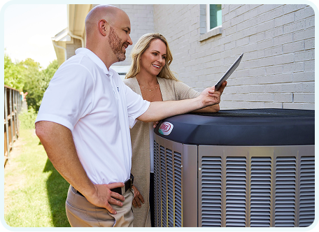 A technician and homeowner discussing a heating and cooling system